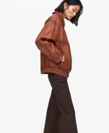 Chaqueta de cuero de ovino en color marrón, de diseño oversize con cuello clásico, cierre frontal con botones a presión y bolsillos frontales con solapa.