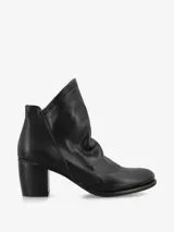 Botín de cuero negro, estilo botín corto o botín Chelsea, con caña arrugada o fruncida y taco ancho y bajo.