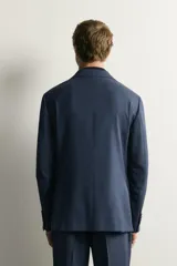 Blazer regular fit azul marino confeccionada en tejido con 20% de lana. Cuenta con cuello con solapas de muesca, manga larga con botones en los puños, bolsillos de vivo en el pecho y de solapa en la cadera, y cierre frontal con botones.