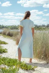 Vestido largo celeste con cuello redondo y mangas cortas con ribete amarillo.