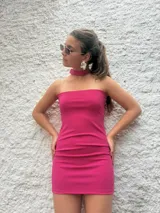Minivestido fucsia strapless con choker al cuello. Puede usarse strapless o con escote halter.