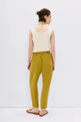Pantalón tipo babucha de tiro alto, color verde mostaza, confeccionado en símil lino. Presenta cintura elastizada con lazo de ajuste y largo al tobillo.