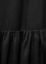 Vestido largo de corte evasé, sin mangas y con cuello redondo. Confeccionado en una mezcla de lino y ramio, presenta un diseño minimalista con falda de vuelo y cierre posterior.