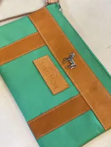 Sobre tipo cartuchera de lona con estampado de camuflaje y terminaciones en cuero marrón.