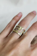 Anillo ancho de bronce con diseño calado irregular.