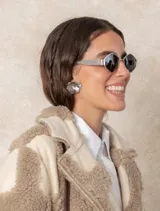 Aros de diseño orgánico en tono plata, con forma de flor y textura lineal con acabado brillante.