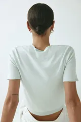 Remera corta de punto fino suave, color verde menta, con ajuste entallado, cuello redondo, mangas cortas y detalles acanalados en cuello, puños y bajo.