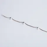 Pulsera semirrígida de plata 925, compuesta por una cadena fina con pequeñas esferas intercaladas a lo largo de toda la pieza.