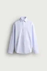 Camisa de vestir de corte regular fit y manga larga, confeccionada en tejido de algodón con sutil textura estructurada en color celeste. Cuenta con cuello italiano y cierre frontal con botonadura.