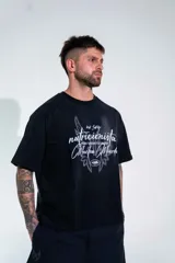 Remera de corte boxy color negro, con mangas cortas y estampa frontal con tipografía manuscrita y diseño gráfico.