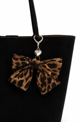 Colgante para bolso con lazo de tela estampado animal print y dije metálico en forma de corazón con cierre de mosquetón.