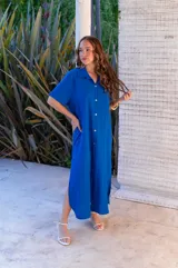 Vestido camisero de muselina color negro, de largo midi, con cuello clásico, manga corta y cierre frontal con botones.