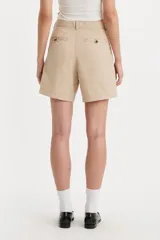 Short de corte sastrero en color beige, con diseño de pinzas frontales, cierre de botón y bragueta, y bolsillos laterales.