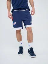 Bermuda deportiva Umbro del Club Nacional de Football, modelo Pro Training, de color azul marino con detalles blancos en el dobladillo. Presenta el escudo del club en una pierna y el logo de la marca en la otra.