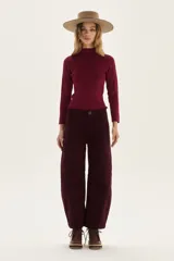 Polera de tejido de punto acanalado en color beige, con cuello alto y mangas largas. Presenta un sutil acabado brillante gracias a sus detalles en lurex.