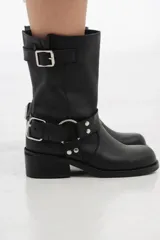 Bota de cuero negra de caña media con hebillas metálicas y taco bajo.