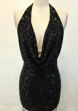 Vestido corto negro con lentejuelas, escote halter profundo con drapeado y espalda descubierta.