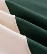 Chomba de manga larga con cuello polo y cierre frontal con botones. Presenta un diseño de rayas horizontales anchas en bloques de color verde y beige. Confeccionada en tejido de algodón de alta calidad.