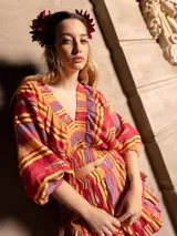 Conjunto de dos piezas compuesto por un top corto de mangas abullonadas con elástico y una falda corta con volados, ambos confeccionados en tela estampada a rayas multicolores.