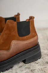 Botines Chelsea de cuero negro, con elástico lateral y suela track.