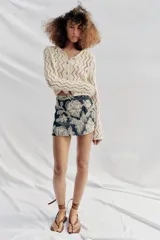 Falda pantalón corta de color azul marino con diseño bordado de flores en hilo crudo, forro interior y cierre lateral con cremallera oculta.