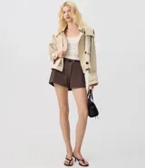 Trench coat cropped beige con capucha, cierre cruzado con botones y mangas largas.