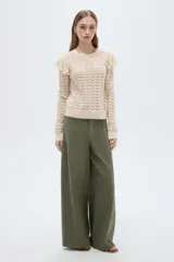 Sweater de algodón color natural, de punto con diseño calado, cuello redondo a la base y mangas largas con volados en los hombros.