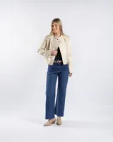 Campera estilo motero de símil cuero en color beige, con cuello alto, cierre frontal asimétrico y paneles acolchados en los hombros.