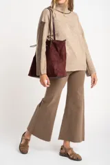 Polera oversize color beige melange, de punto con mangas largas y detalles de franjas marrones en las mangas y cuello.