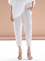 Pantalón de lino a rayas verticales color gris y blanco, con cinturón de la misma tela.