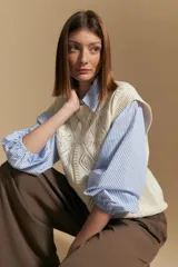 Chaleco tejido color crema con diseño de rombos calados, cuello redondo y sisas.