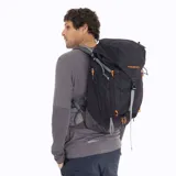 Mochila de trekking Merrell modelo Grayling de 30 litros, color negro con detalles en naranja vibrante en cierres y cordones. Presenta un logo 'M' en naranja en la parte superior y la marca 'MERRELL' en naranja en el bolsillo frontal inferior.