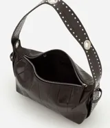 Bolso tipo baguette de material sintético con textura de relieve geométrico. Presenta un asa corta ajustable decorada con tachas metálicas y ojales, cierre superior con cremallera y herrajes metálicos.