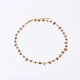 Collar corto con cadena dorada y cuentas de piedra natural color ladrillo.