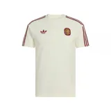 Remera de algodón color crema con diseño de la selección de España. Presenta el logo del trébol de adidas Originals y el escudo de la selección en color bordó en el pecho, junto con las tres tiras características de la marca en los hombros en el mismo tono.