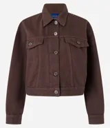 Campera marrón de sarga de algodón, corte regular, cuello inglés, manga larga, abotonada al frente, con bolsillos con solapa en el pecho y pliegues en la parte baja.