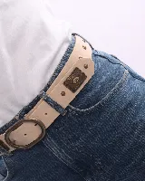 Cinturón de cuero color beige con hebilla ovalada y apliques metálicos decorativos en tono oro viejo.