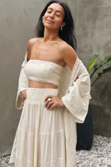 Conjunto compuesto por un top fruncido strapless de algodón con detalle de lurex y una falda larga fluida de talle alto con volantes y cintura fruncida.
