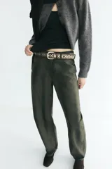 Jeans de tiro medio con corte barrel leg y diseño de cinco bolsillos. Presenta un acabado con efecto lavado y tintado único, con cierre frontal de cremallera y botón.