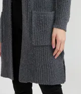 Cardigan largo de punto abierto, color marrón tostado, con mangas largas y dos bolsillos delanteros aplicados. Presenta una textura acanalada y diseño sin cierre.