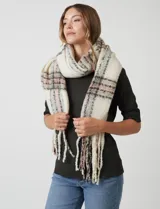 Bufandón de tejido soft, color crema con patrón a cuadros en tonos rosa pálido, gris y negro. Presenta terminación con flecos.