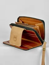 Billetera pequeña tricolor de cuero con cierre de broche y correa de mano. Presenta un logo de búho grabado en el frente.