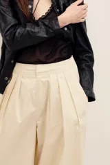 Pantalón de corte holgado confeccionado en algodón, tiro alto, con bolsillos laterales y pinzas frontales.