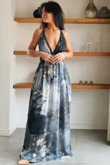 Vestido largo de seda con estampado abstracto en tonos marrones, beige y destellos dorados, con escote en V profundo, tirantes de cuerda anudados al cuello y la cintura, y tajo lateral en la falda.