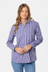 Camisa holgada de manga larga, color azul con rayas verticales blancas, cuello clásico y bolsillo en el pecho.