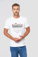 Remera de manga corta con cuello redondo, color blanco, con estampa frontal que incluye un paisaje de bosque y el texto 'Legacy'.