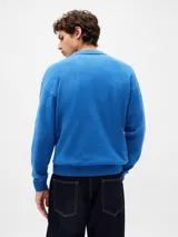 Buzo tipo polo de tejido suave, con cuello clásico, cierre frontal de botones y puños y ruedo acanalados.