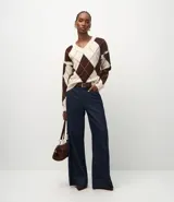 Suéter de punto con diseño de cuadros argyle en tonos marrón y crema, cuello en V y mangas largas con sisa caída.