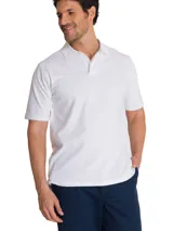 Remera tipo polo de manga corta color blanco, con cuello de punto acanalado y tapeta con botones. Presenta el logo de la marca CAT bordado en el pecho y un detalle de triángulo amarillo en la manga.