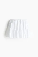 Pollera mini blanca con cintura elástica y diseño con volados fruncidos.